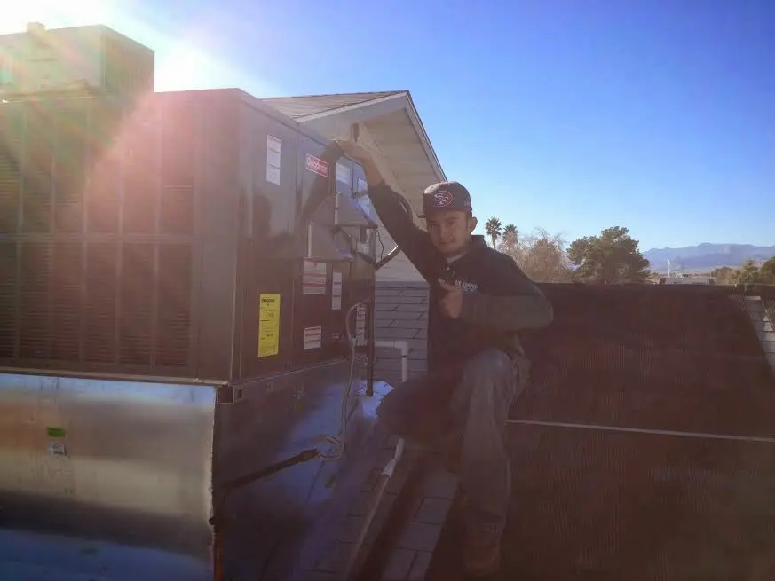HVAC technician performing HVAC Inspection on a rooftop unit in Queen Creek